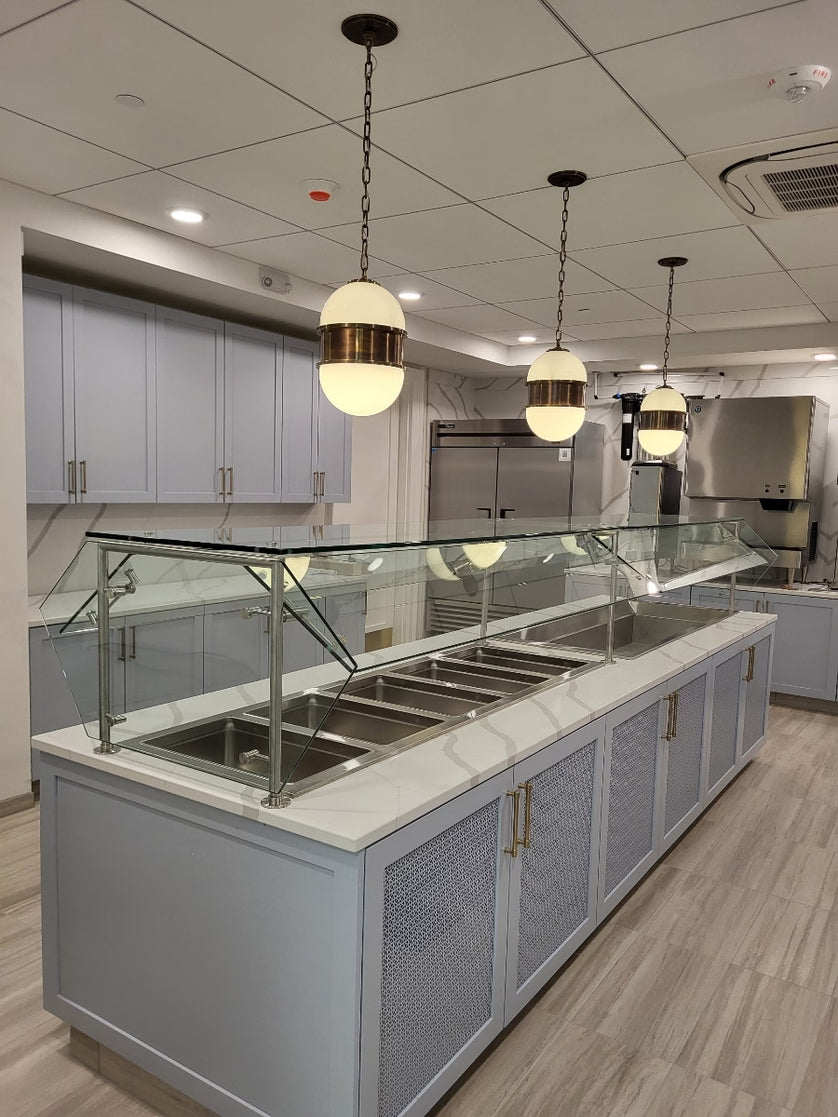 Modern kitchen with a glass display counter and pendant lights.