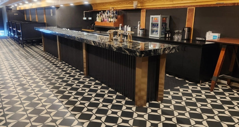 Bar area with a marble countertop and patterned black and white floor