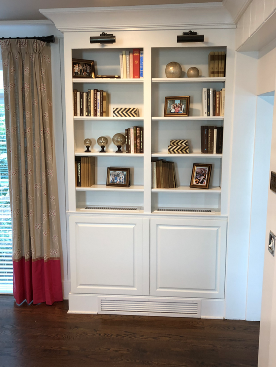White bookshelf with decorative items in a room with curtains and a wooden floor.