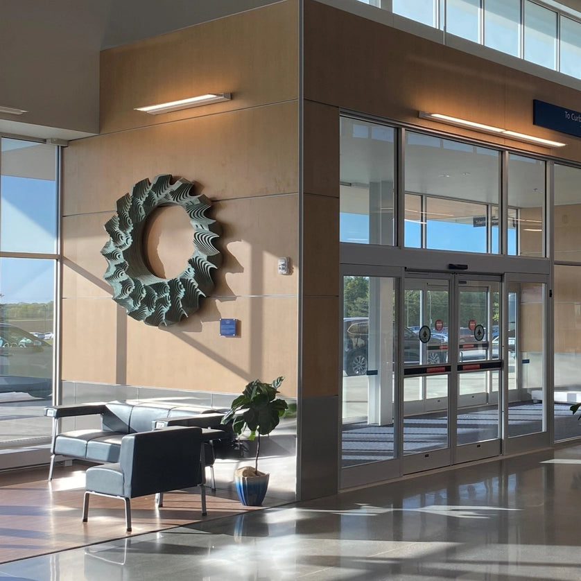 Interior of a building with architectural panels, glass doors, and decorative wall art.
