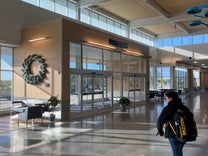 Interior of a building with architectural panels, glass doors, and decorative wall art.