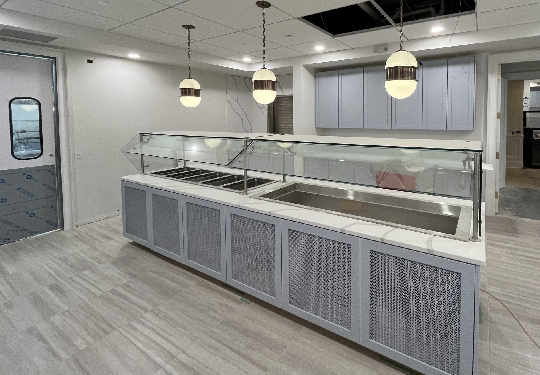 Modern kitchen with stainless steel sinks and gray cabinets.