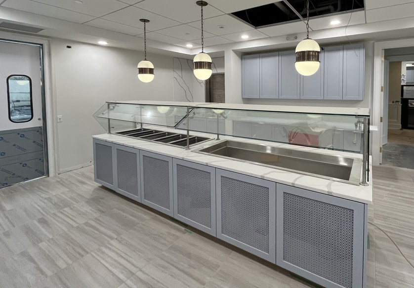 Modern kitchen with stainless steel sinks and gray cabinets.