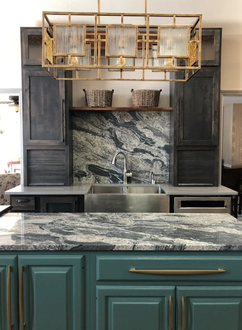 Modern kitchen with green cabinets, granite countertops and full height splash. Gold light fixture.