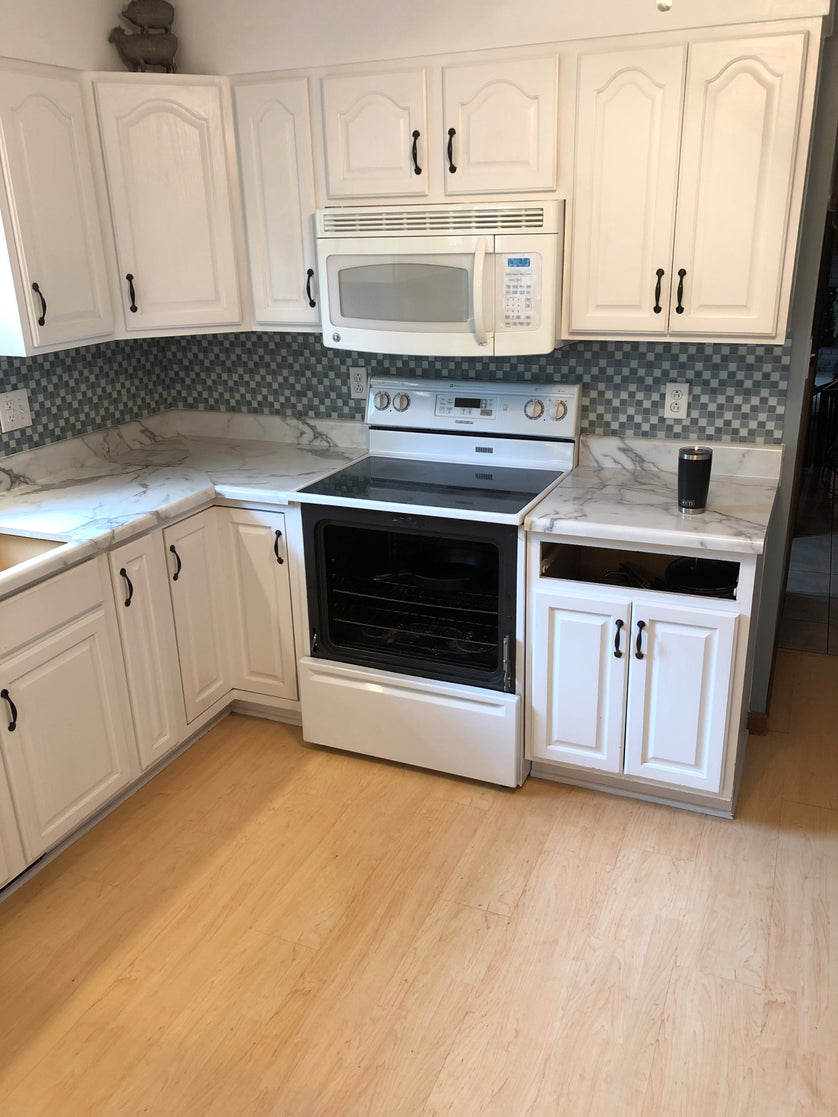 Kitchen with white cabinets, marble countertops, and stainless steel appliances.